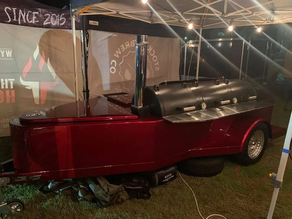 Red Jambo J5 trailer pit at night under a tent with stainless shelves