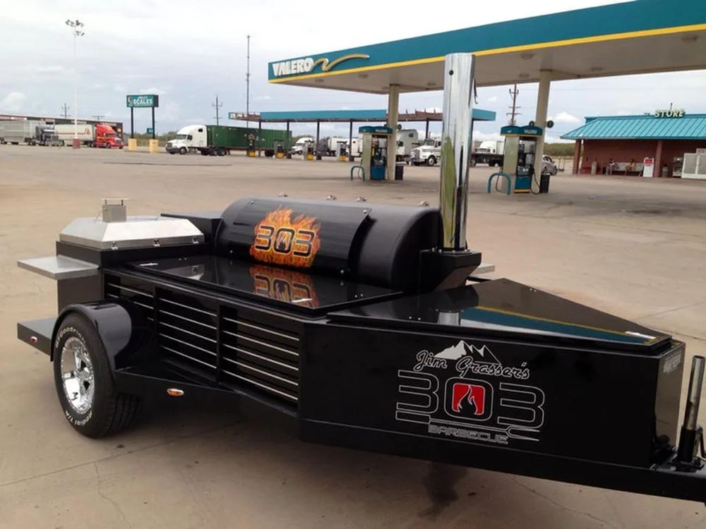 Black Jambo J3 trailer pit with custom graphics parked at a fuel station
