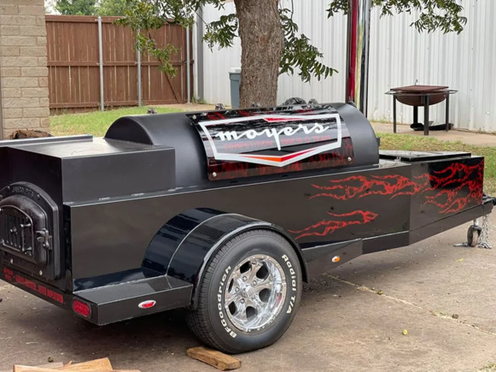 Black Jambo J3 trailer with custom red graphics and firebox door, rear three-quarter view